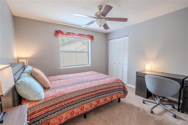 carpeted bedroom with ceiling fan, a textured ceiling, and a closet