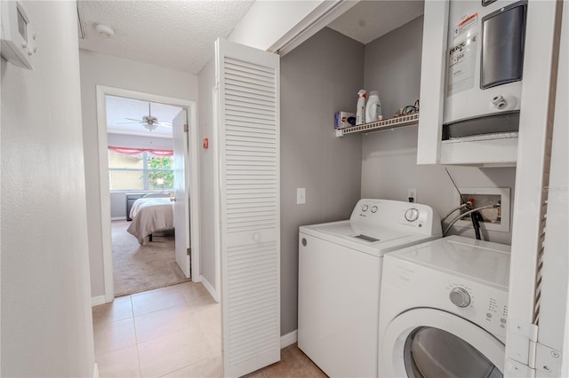 laundry area featuring light tile patterned flooring, washer and clothes dryer, ceiling fan, and a textured ceiling