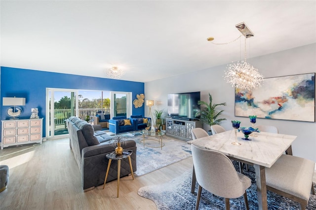 living room with a notable chandelier and light hardwood / wood-style flooring