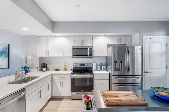 kitchen featuring appliances with stainless steel finishes, sink, white cabinets, and backsplash