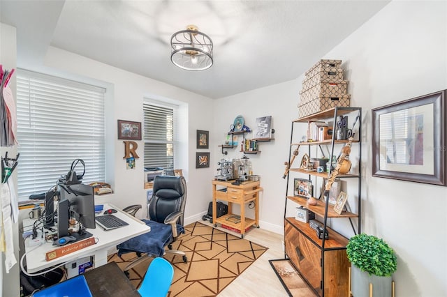 office space featuring a chandelier and light wood-type flooring