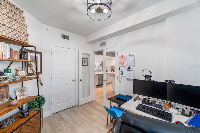 office space with light hardwood / wood-style flooring, french doors, and a chandelier