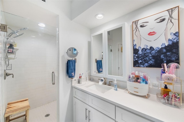 bathroom featuring a shower with door and vanity