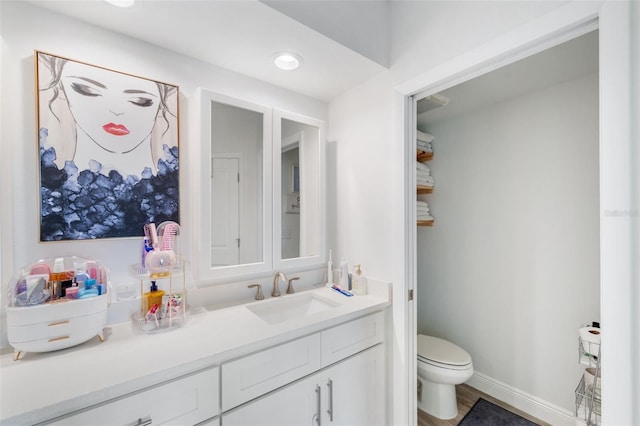 bathroom with vanity, hardwood / wood-style flooring, and toilet