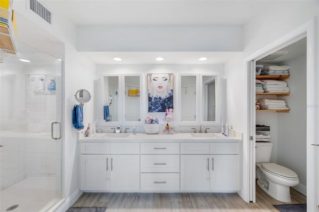 bathroom featuring vanity, hardwood / wood-style flooring, toilet, and walk in shower