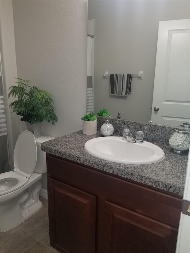 bathroom with tile patterned floors, vanity, and toilet