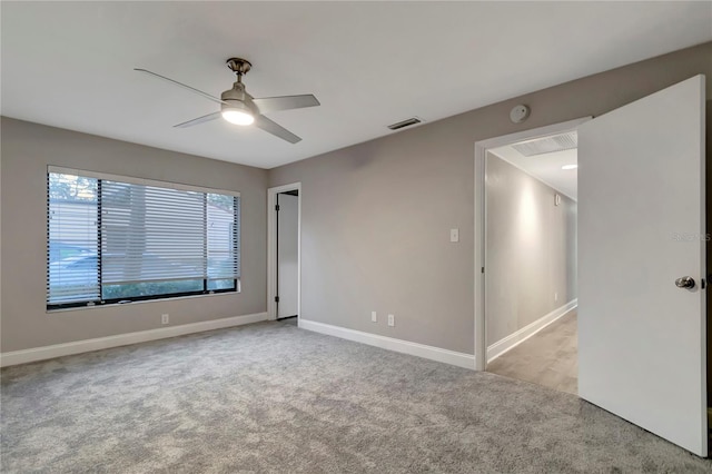 spare room featuring light colored carpet and ceiling fan