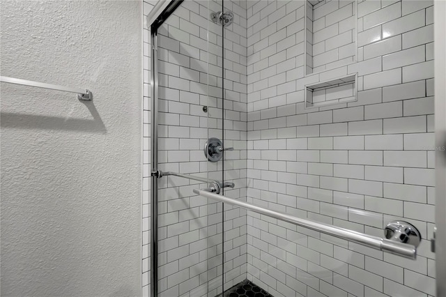 bathroom featuring a shower with shower door