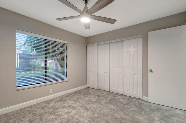 unfurnished bedroom with ceiling fan, light colored carpet, and a closet