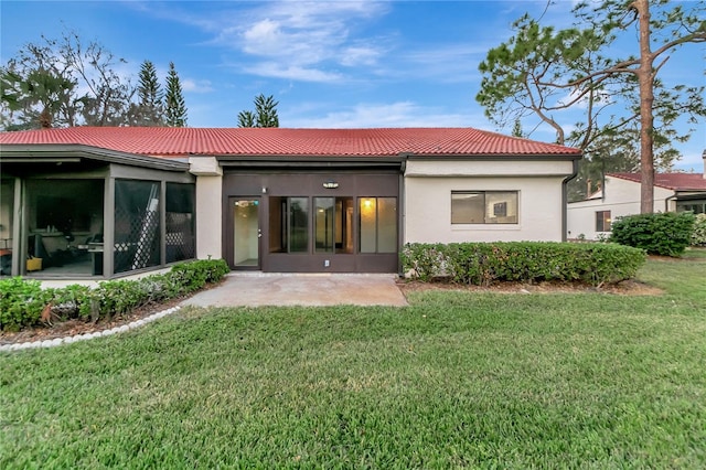 back of property with a yard and a patio