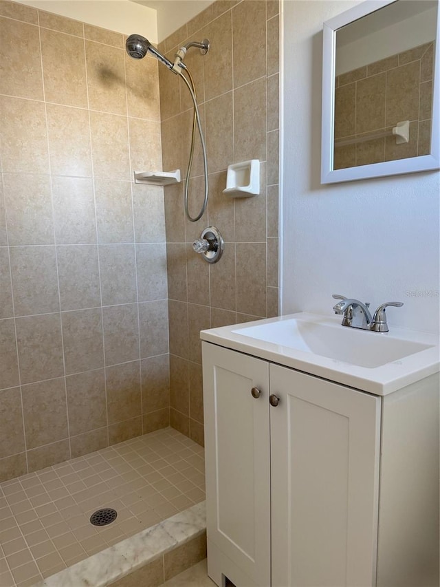 bathroom with vanity and tiled shower