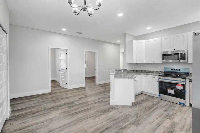 kitchen featuring white cabinetry, light hardwood / wood-style floors, kitchen peninsula, appliances with stainless steel finishes, and light stone countertops