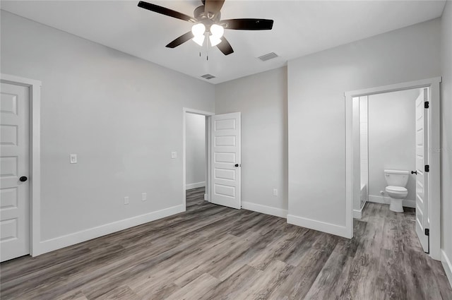 unfurnished bedroom with ceiling fan, connected bathroom, and hardwood / wood-style flooring