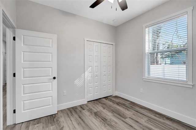 unfurnished bedroom with a closet, light hardwood / wood-style flooring, and ceiling fan