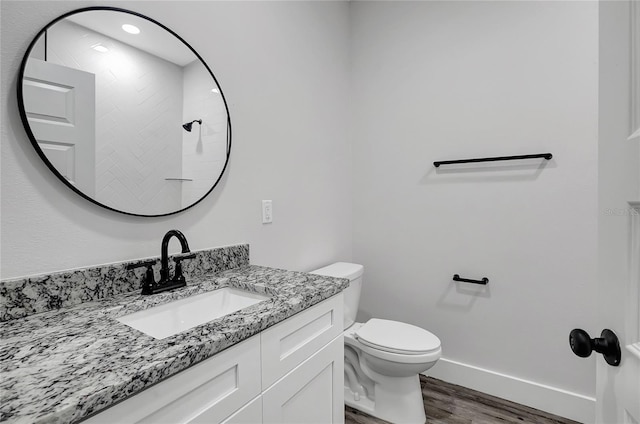 bathroom featuring toilet, hardwood / wood-style flooring, and vanity