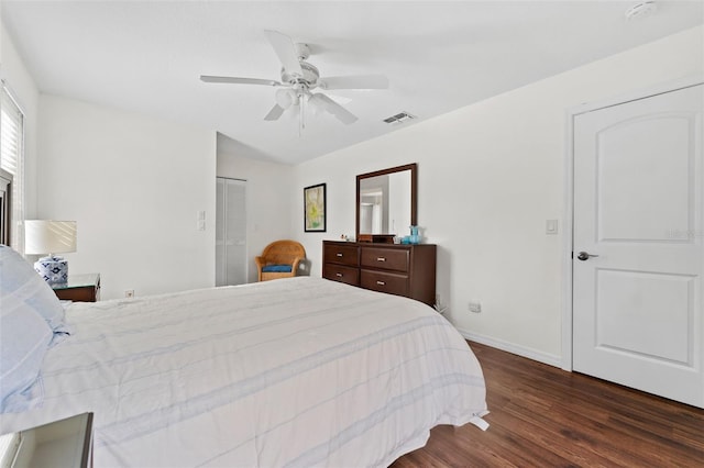 bedroom with ceiling fan, dark wood-type flooring, and a closet