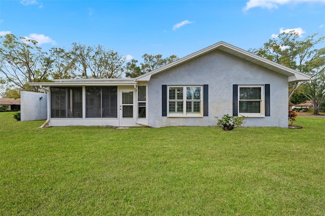 back of house featuring a yard and a sunroom