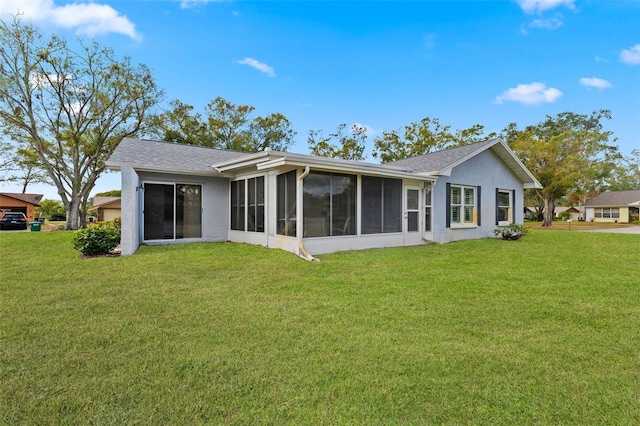 rear view of house with a sunroom and a yard