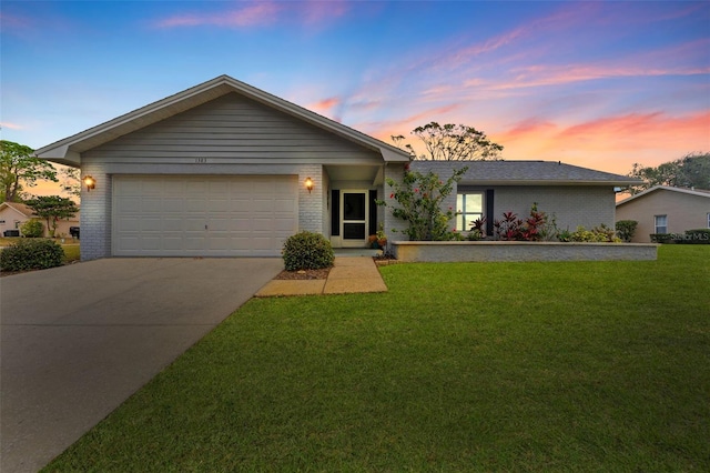 ranch-style home featuring a garage and a lawn