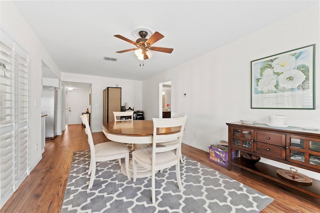 dining space with ceiling fan and hardwood / wood-style floors