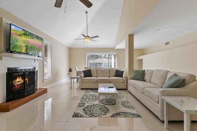 living room with lofted ceiling, ceiling fan, and light tile patterned floors