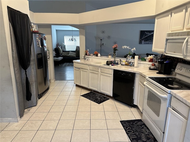 kitchen featuring white appliances, light tile patterned floors, an inviting chandelier, white cabinets, and sink