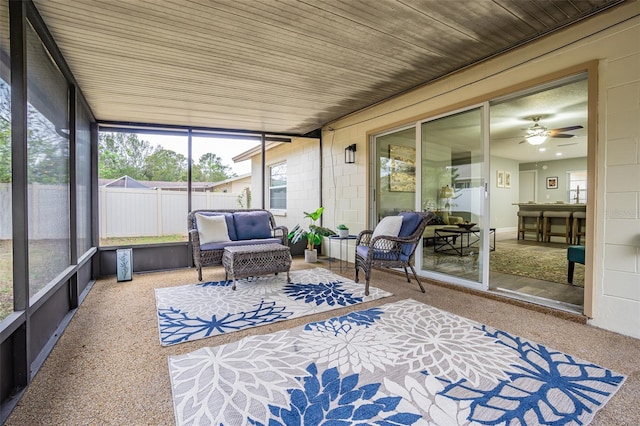 sunroom featuring ceiling fan and wooden ceiling