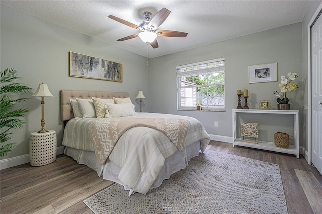 bedroom with hardwood / wood-style floors, a textured ceiling, and ceiling fan