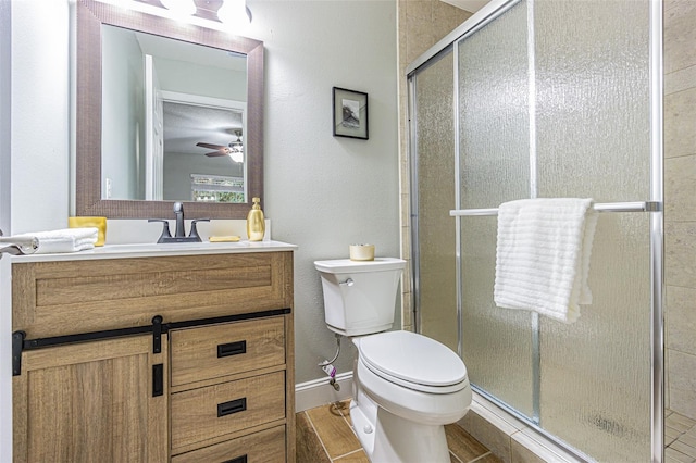 bathroom with ceiling fan, vanity, a shower with shower door, and toilet