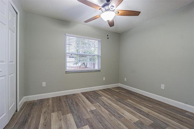 unfurnished bedroom with ceiling fan, a closet, a textured ceiling, and dark hardwood / wood-style floors