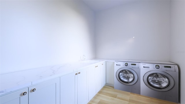 laundry area with washer and dryer, cabinets, sink, and light hardwood / wood-style floors