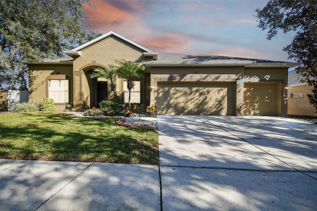 view of front facade featuring a lawn and a garage