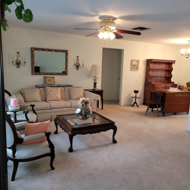 carpeted living room featuring ceiling fan with notable chandelier