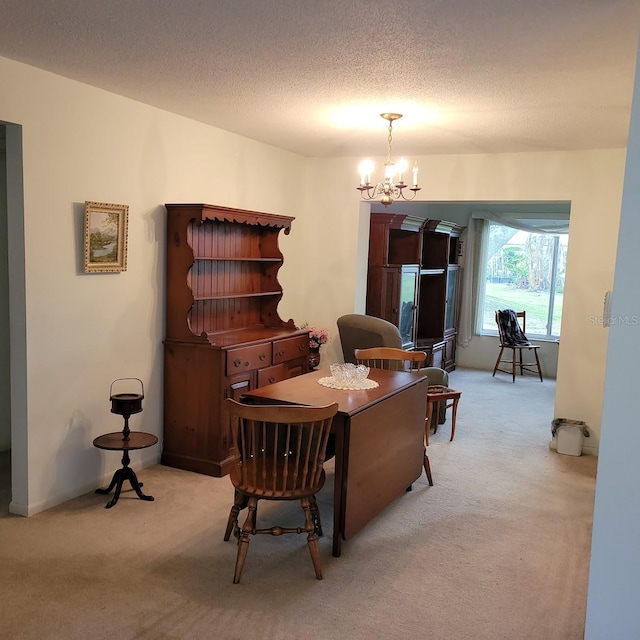 carpeted dining space featuring a textured ceiling and a notable chandelier