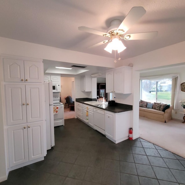 kitchen featuring white cabinetry, dark carpet, ceiling fan, white appliances, and sink