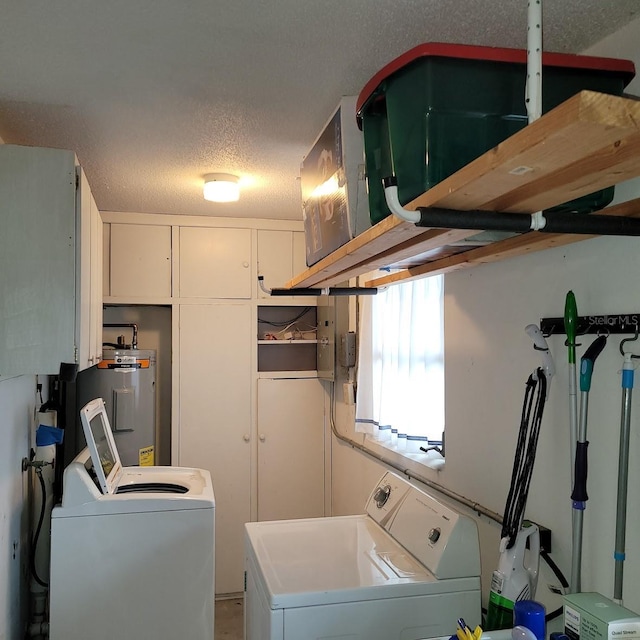 laundry room featuring electric water heater, washing machine and dryer, and a textured ceiling