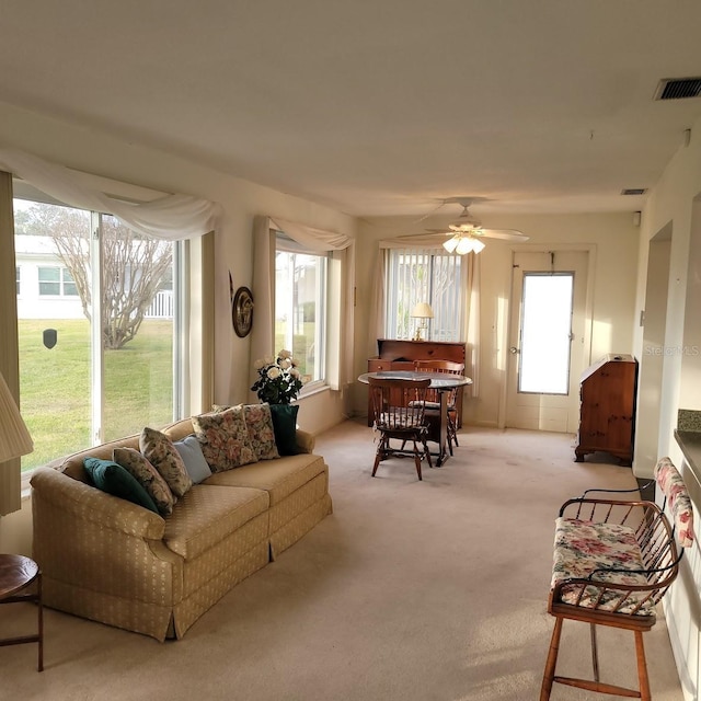 carpeted living room with ceiling fan