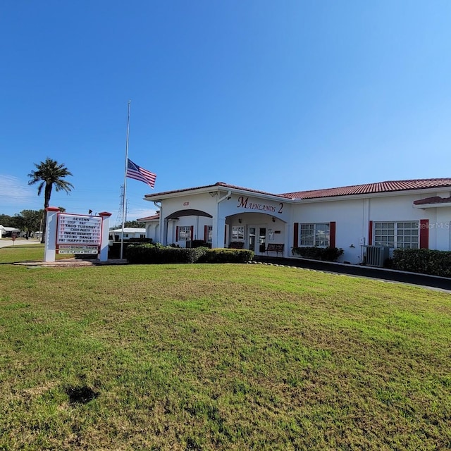 view of front of house featuring a front lawn, french doors, and central AC