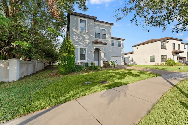 mediterranean / spanish home featuring a front lawn and a garage