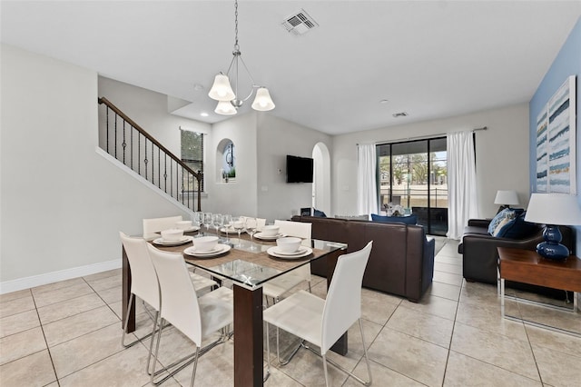 dining space with a notable chandelier and light tile patterned flooring