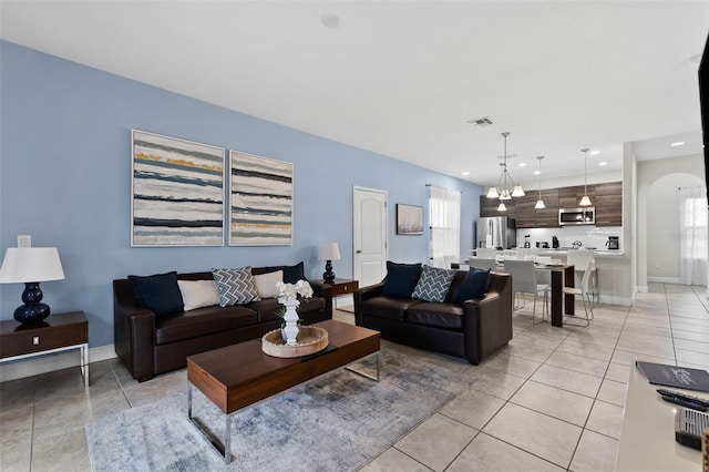 tiled living room featuring a notable chandelier