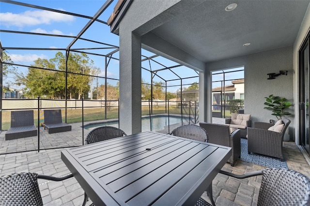 view of patio / terrace featuring glass enclosure, a fenced in pool, and outdoor lounge area