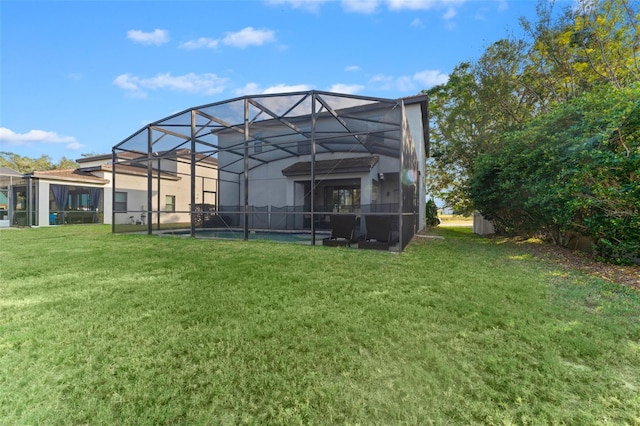 rear view of property featuring a yard and glass enclosure