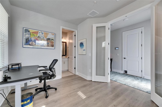 office space with light wood-type flooring and french doors