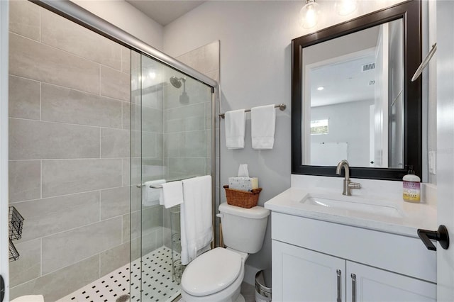 bathroom with toilet, a shower with door, and vanity