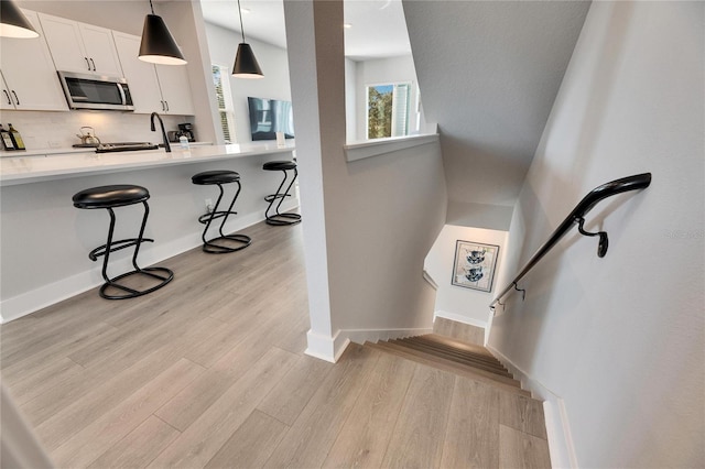 staircase with sink and wood-type flooring