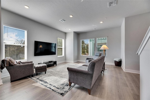 living room featuring a textured ceiling and light wood-type flooring