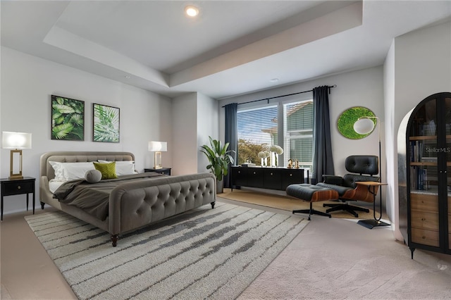 bedroom with a raised ceiling and carpet floors