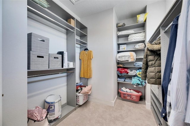 walk in closet featuring light carpet