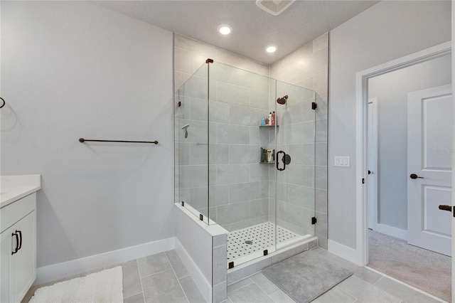 bathroom with tile patterned flooring, a shower with shower door, and vanity